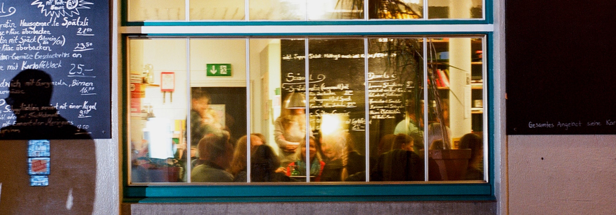 Abendlicher Blick durch das Fenster ins Café Zähringer, Zürich